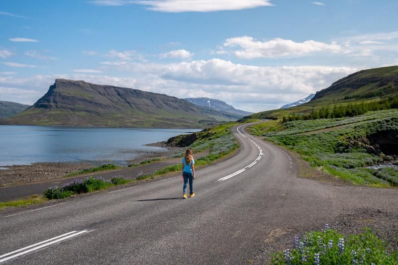 A girl walking on an empty road in Iceland