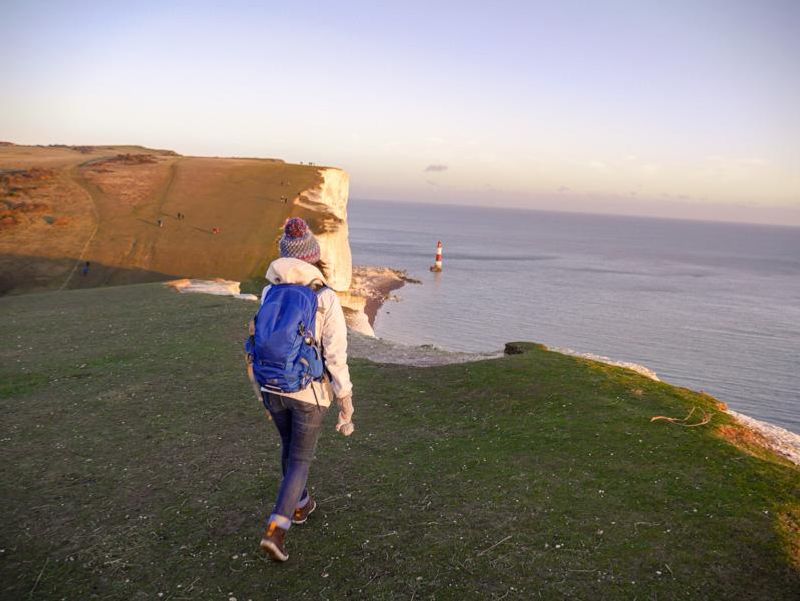 A girl walking towards the cliff in Beachy Head in East Sussex, England